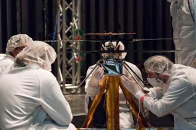 Mars Helicopter team members work on the flight model (that is going to Mars) in the Space Simulator, a 25-foot-wide (7.62 meters) vacuum chamber, at NASA's Jet Propulsion Laboratory in Pasadena, California. (Source: NASA/JPL-Caltech)