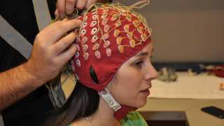 Ashley Livingstone, an SFU first year master's student, models a cap that is fitted with 128 electrodes. They are hooked up to monitor the wearer's brain activity. 