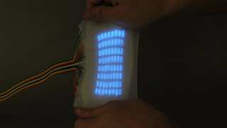 These are multi-pixel electroluminescent displays fabricated via replica molding. The device measures 5 mm thick, with each of the 64 pixels measuring 4 mm. It can be deformed and stretched in various ways
